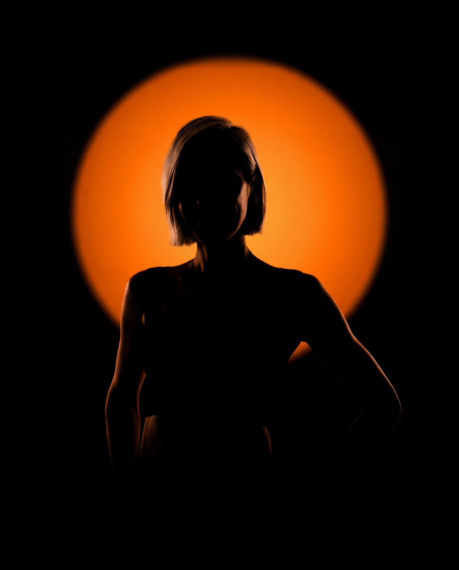 Nelly Ilyasova in silhouette against a warm orange light
